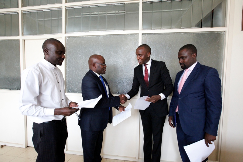 (on the left) General Secretary UCA shakes hand with Moses Mugisha from Puliida after the signing the MOU Image